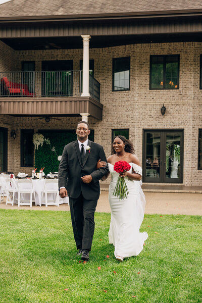 Bride walking down the aisle with her father during the wedding ceremony at Naimoli Estate.
