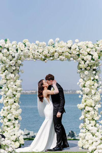 Chic bride and groom drive along San Diego coastline in vintage Porsche convertible after their wedding