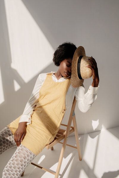fashionable woman wearing a yellow dress and straw hat