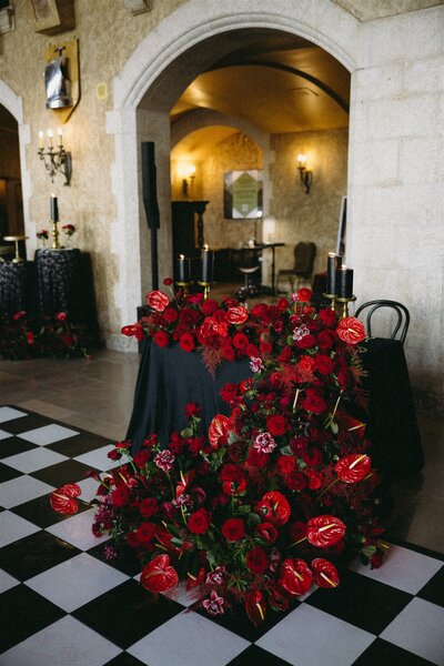 Cascading red florals on a black table for moody wedding vibes.