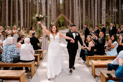 bride and groom leaving wedding ceremony in the woods