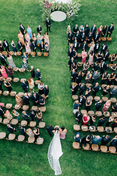 Bride and Groom share a kiss in front of a vintage car surrounded by fall trees. Photo by Anna Brace, a wedding photographer in Omaha NE.