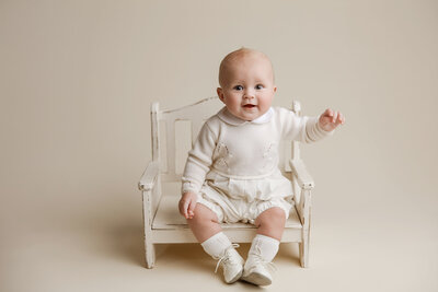 boy in blue outfit on blue backdrop for milestone session