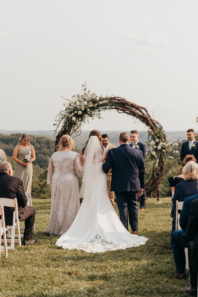engagement photo of couple kissing while holding a flower