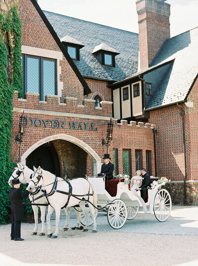 Elegant wedding arrival at Dover Hall Estate featuring a white horse-drawn carriage and brick architecture