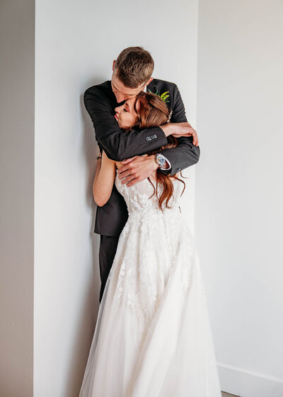 Couple hugging tightly by a wall
