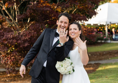bride and groom smiling while standing in a field