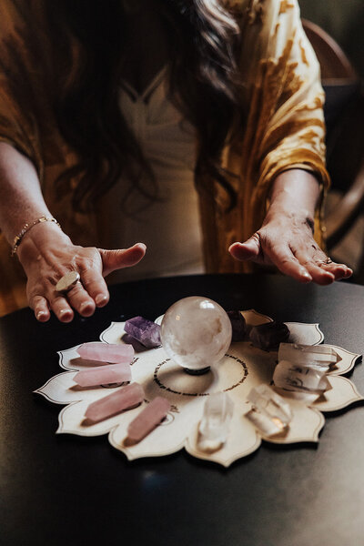 a woman with her hands stretched out over a crystal grid 
