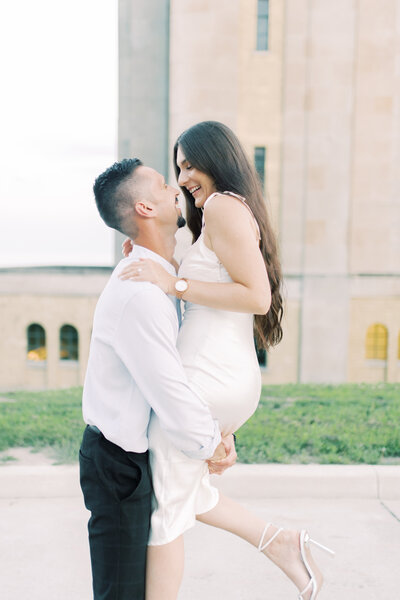 Groom lifting the bride in a playful and romantic embrace at Toronto’s RC Water Plant, both laughing in pure joy
