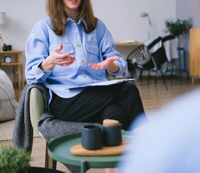 Woman talking to another with a notebook and pen