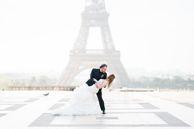 Groom dipping bride in front of the eiffell tower in Fance