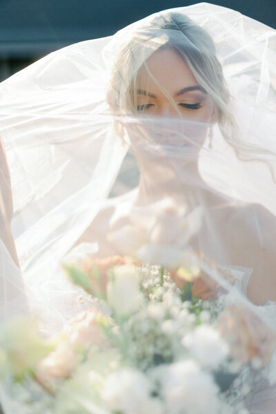 Side view of bride holding veil