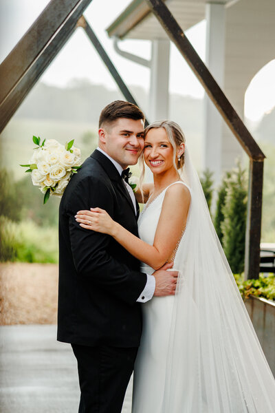 Couple smiling at the camera under open air chapel.