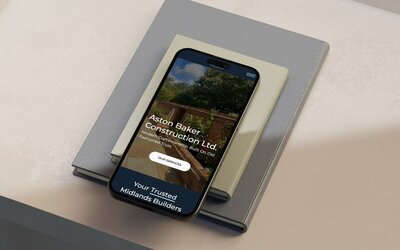 iphone on a book showing Aston Baker Construction website design