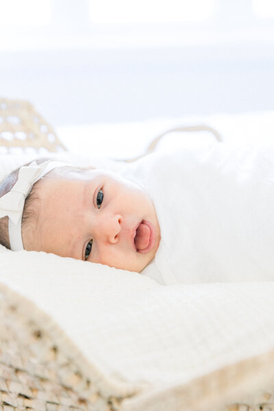mama holding newborn baby in bed byBURLINGTON NEWBORN PHOTOGRAPHER