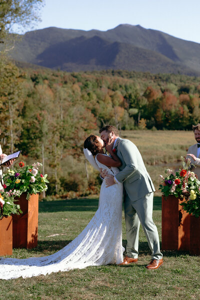 Vermont Wedding Photographers | Sincerely Liz Photography Documentary Wedding, Engagement, Elopement, Maternity and Newborn Photographer in New England | Bride and groom kiss at the aisle in an outdoor mountain venue in New England