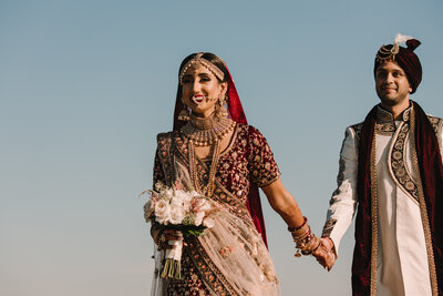 A newlywed couple holding hands and walking together 
