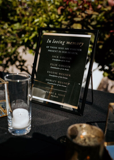 In loving memory sign in black and gold displayed in a black frame at a spring wedding at the Palm Event Center in Pleasanton, CA.