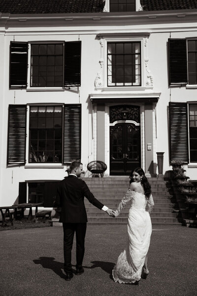 Editorial bruidsfotograaf bij een bruidspaar voor een oud landhuis