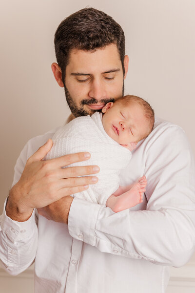 Dad holds newborn for portrait at a studio in Richmond, VA.