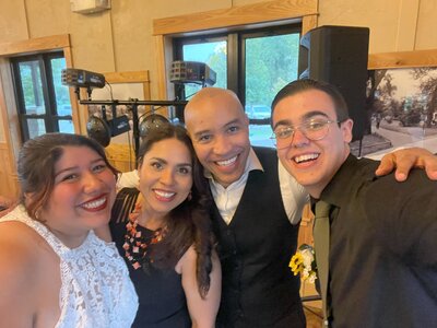 wedding videographer ariel poses for photo with albert lea couple. groom wears glasses