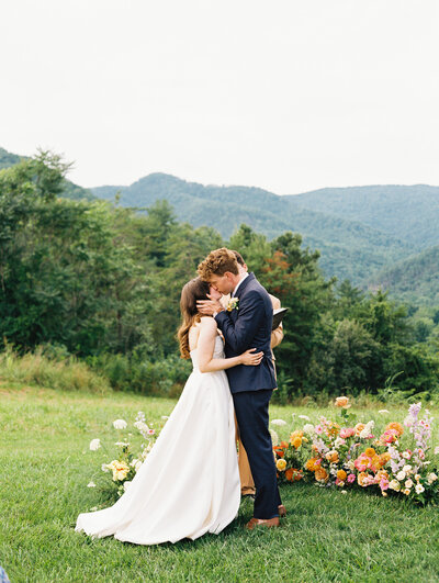 The first kiss, as bride and groom are officially wed in the hills of North Carolina, by destination photographer Megan Lynn of My Sun and Stars Co.