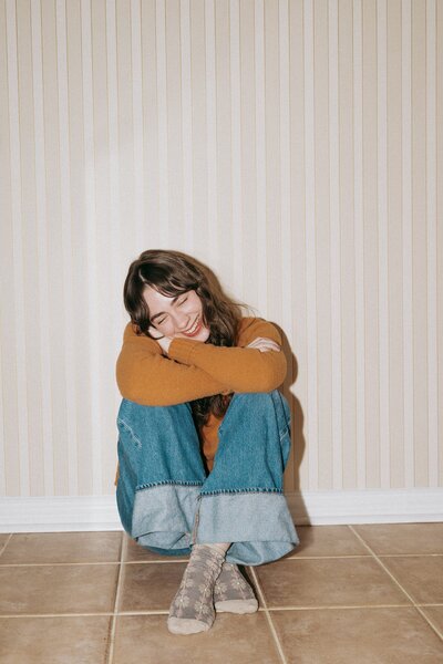 photographer brand photos sittting against a striped wall