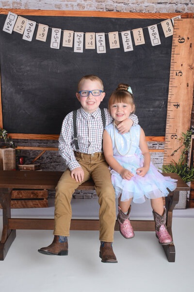 mom little sister and big brother smile at their photoshoot