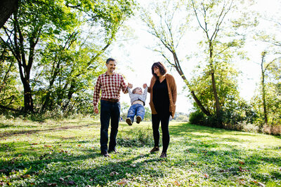 Family of three playing in the park in Hudson Valley, New York in the Spring.