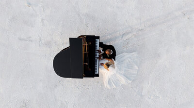 couple playing piano together on the salt flats during their elopement.