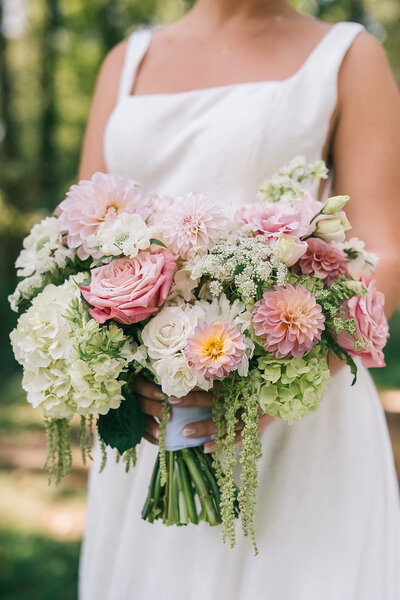 Bride holding pink and green bouquet designed by Abby Grace Florals at Anderson SC wedding