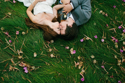 Maravilla Gardens wedding couple photo laying in grass kissing