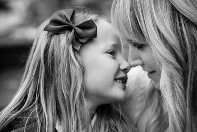 Stunning black and white photograph of a mother and daughter kissing noses during a family photoshoot
