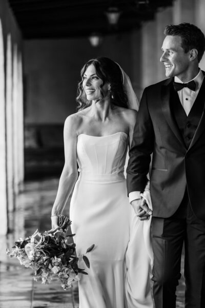 Bride and Groom walk down corridor looking out at their guests