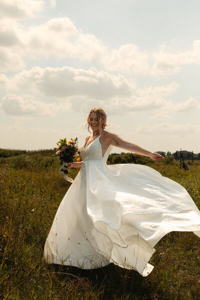 Bride in the filed with her dress floating in the wind