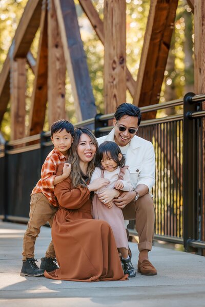 Family on a wooden bridge in Bothell, WA, enjoying a peaceful moment during a lifestyle session.