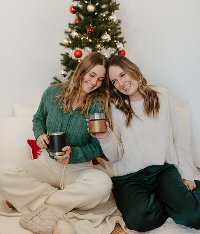 two girls in san diego in front of christmas tree holding asobu mugs