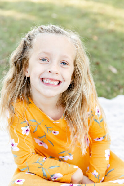 Portrait of young girl smiling for family images.