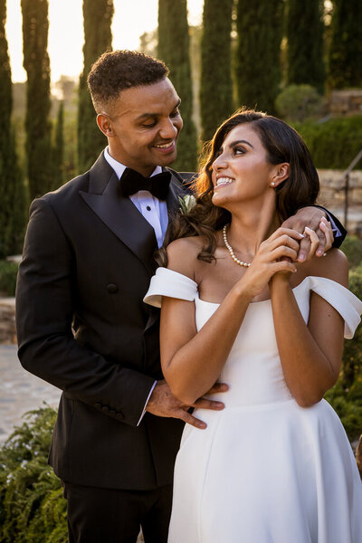 Bride and groom laughing and embracing 
