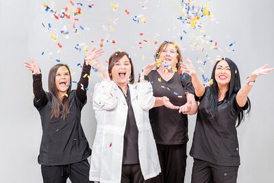 Nurses throwing confetti in the air to celebrate a new service