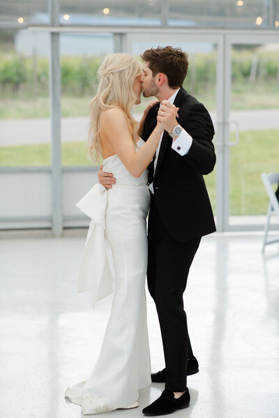 A bride and groom hold each other while performing their first dance.