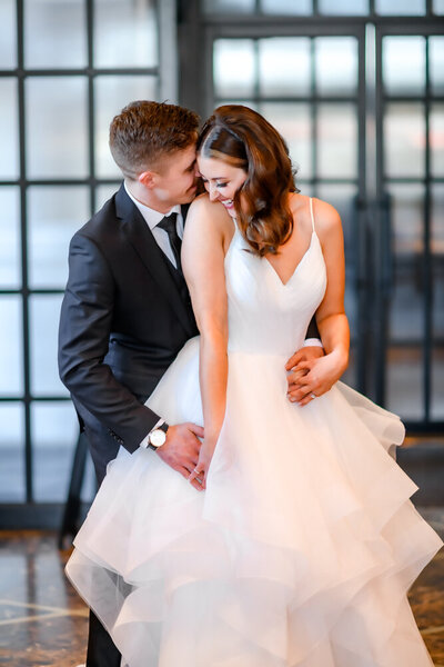 Groom whispers in brides ear during portrait at Broadview Hotel