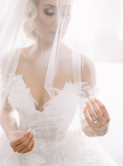 Bride admiring her veil as she gets ready for her wedding