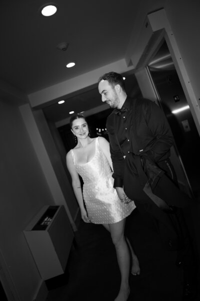 Bride changes into party-ready reception look, captured with harsh flash for editorial feel.