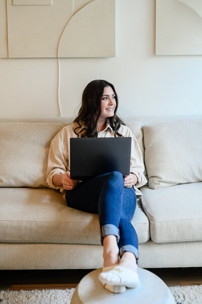 blog writer sitting on the couch with her laptop