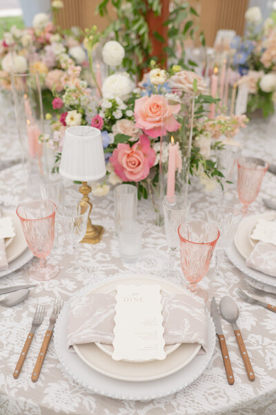 Luxury tented wedding reception with floral-filled dinner table design at an elegant private estate