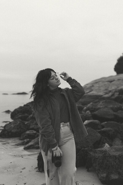 black and white photo of photographer on rocky beach