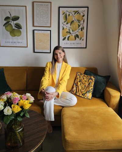 Female founder sitting on a couch smiling