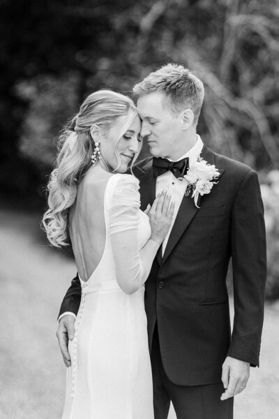 Groom wearing sunglasses and holding brides hand on outdoor steps