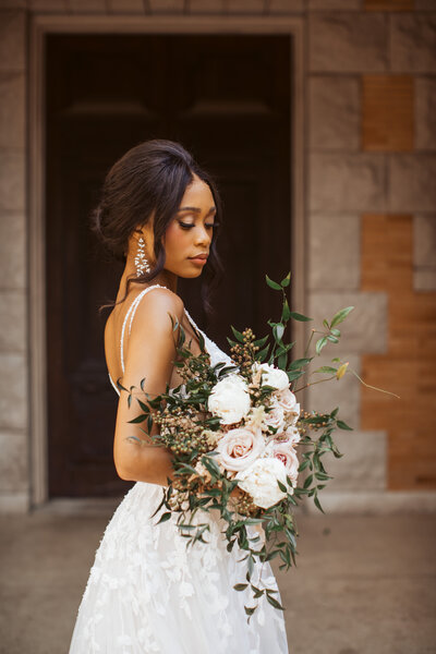 Elegant bridal portrait in lace gown holding a romantic bouquet, photographed by Katie Arnold in Portland, Maine.